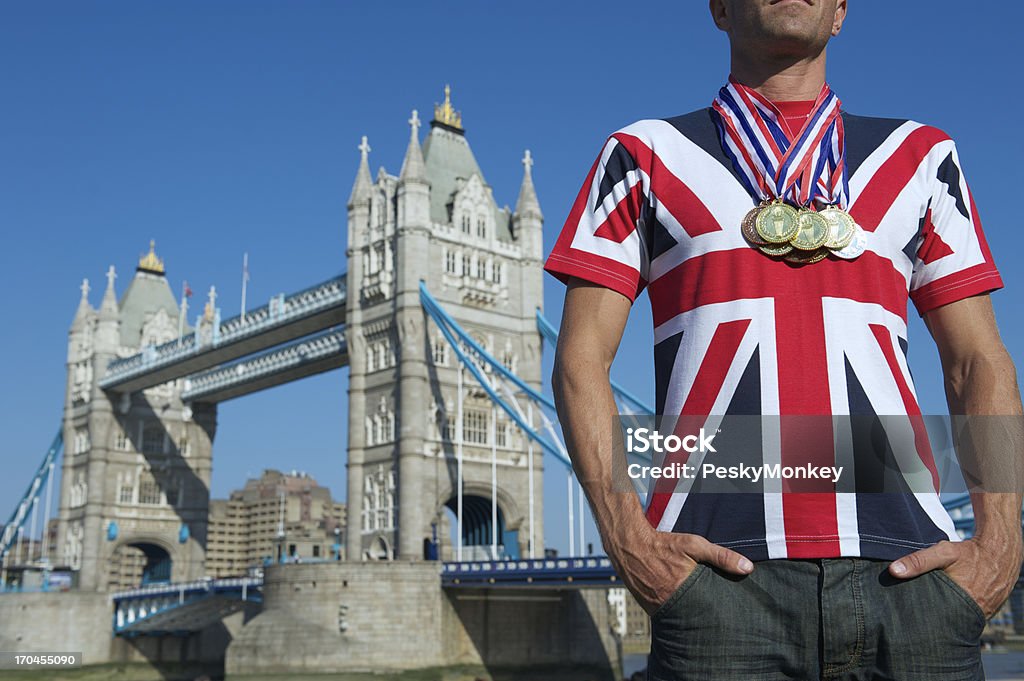 Mann im Union Jack steht im Tower Bridge, mit Medaillen - Lizenzfrei Britische Flagge Stock-Foto