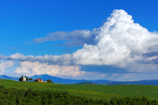 Cappella di Vitaleta, Val d'Orcia, Tuscany, Italy in the spring with a huge cumulonimbus cloud in the background