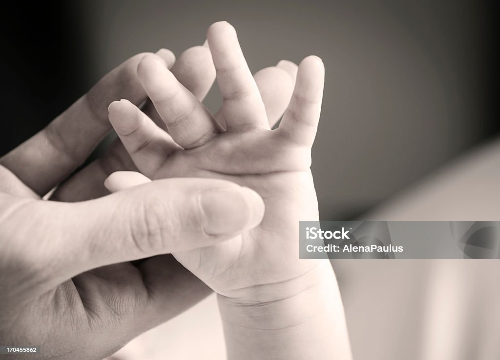 Mother holding baby's hand Mother holding baby's hand; black and white photography. Child Stock Photo