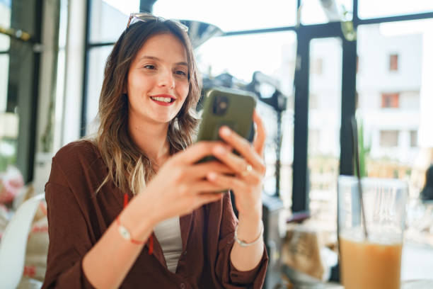 istock Woman using mobile phone at coffee shop. 1704567529