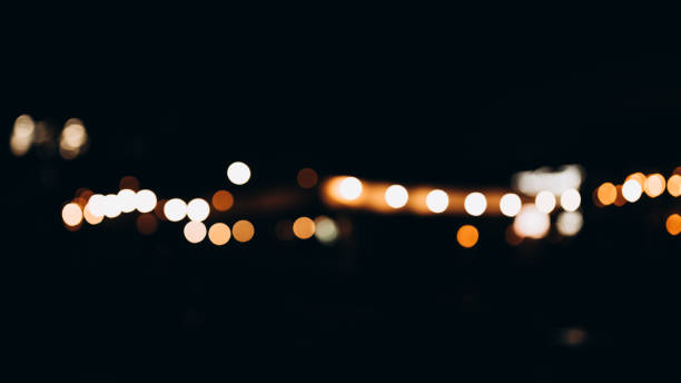 istock Decorative string lights at night time, Defocused Background, night city life backdrop, party time with Yellow bokeh balls. Warm festive bokeh of string lights over an outdoor bar or patio at twilight 1704568092