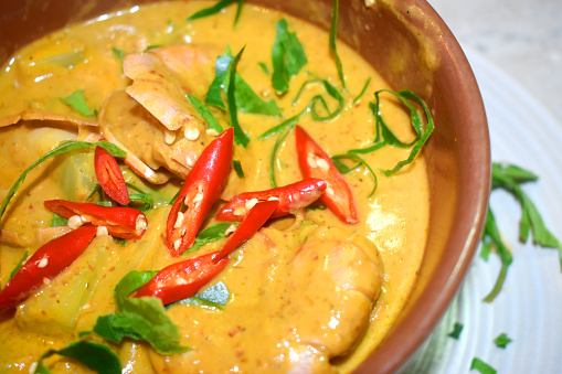 Close-up of Panang curry or  King Prawns Red Curry seasoning with slice red chili and Kaffir lime leaves on the top, Homemade cooking Thai food style.