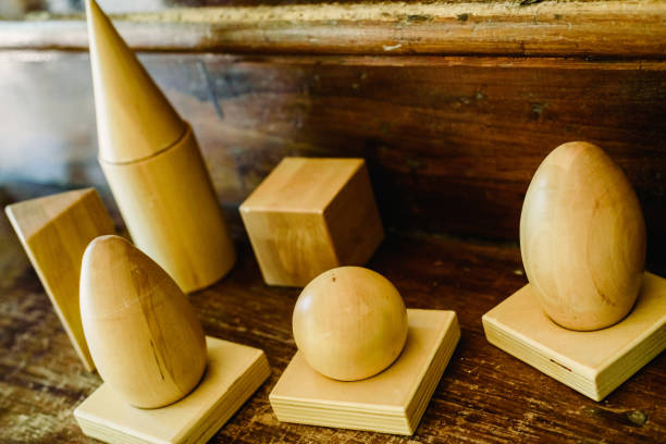 istock Solid wood shapes to study geometry and volumes, cones, triangles, squares, spheres on a warm wood background. 1704586412