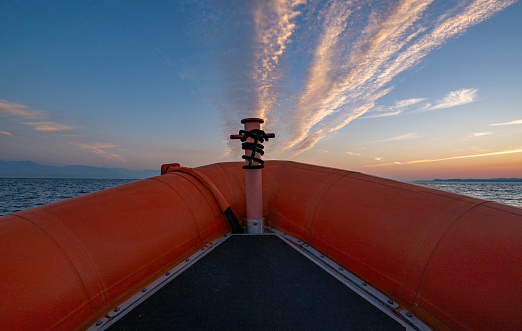 Zodiac ride during a vibrant sunrise in the Strait of Juan de Fuca near San Juan Islands and Victoria, Canada.