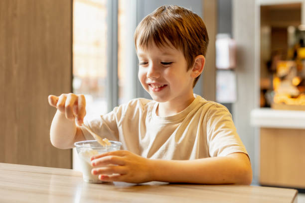 istock 6 year old boy eats ice cream in a cafe 1704625022