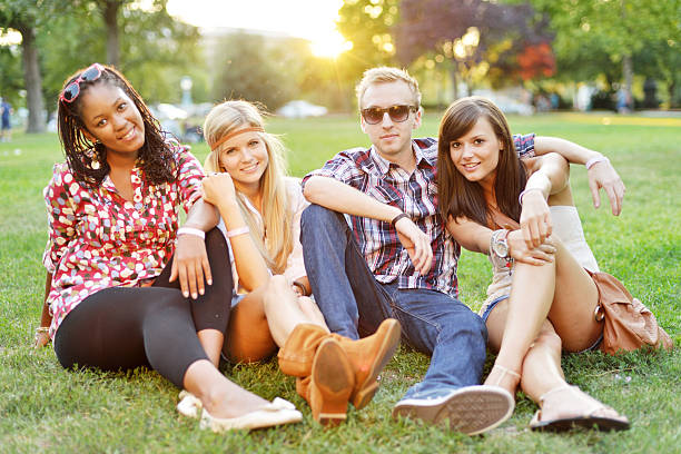 Young beautiful college students sitting together in the park.