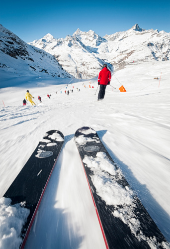 Skiing at speed down a red piste at the alpine Swiss resort of Zermatt.