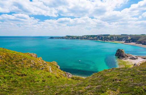 Panoramic view of elephant like sea cliff with sapphire blue sea and town in Étretat