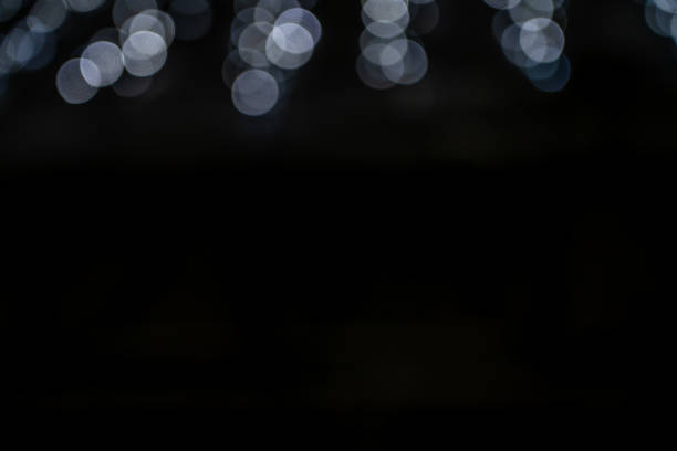 istock White glitter vintage lights with black background. Defocused 1704630473