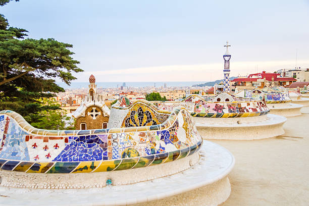 Colorful mosaic benches at the Gaudi-designed Park Guell View of colorful ceramic mosaic bench of park Guell, designed by Antonio Gaudi, in Barcelona, Spain antoni gaudí stock pictures, royalty-free photos & images