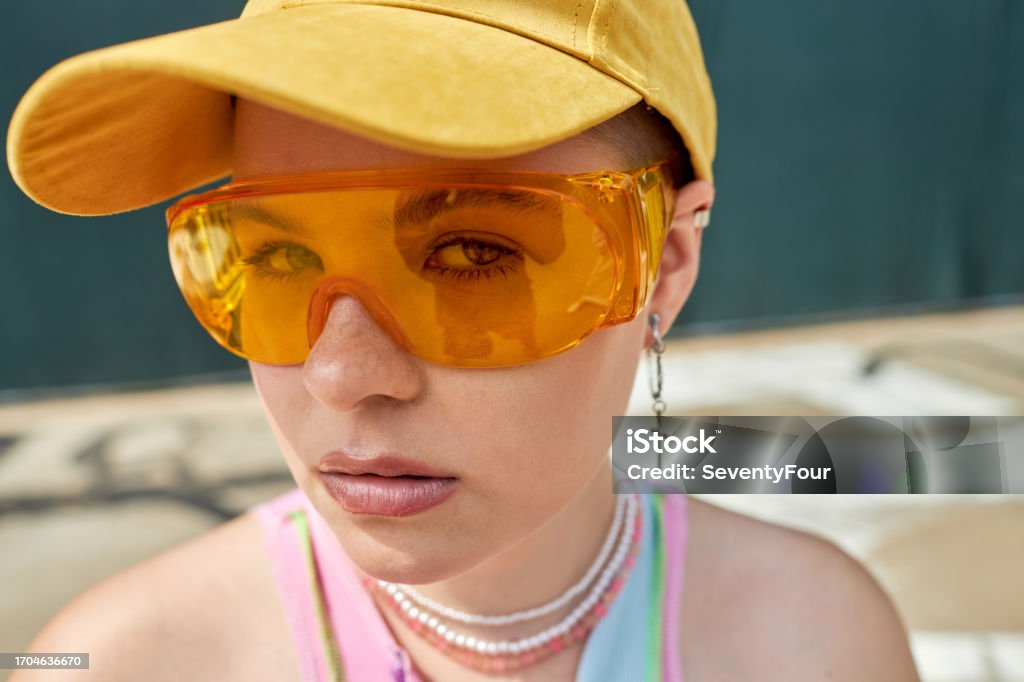Girl looking at camera with yellow sunglasses Closeup portrait of young girl looking at camera with yellow sunglasses, copy space 20-24 Years Stock Photo