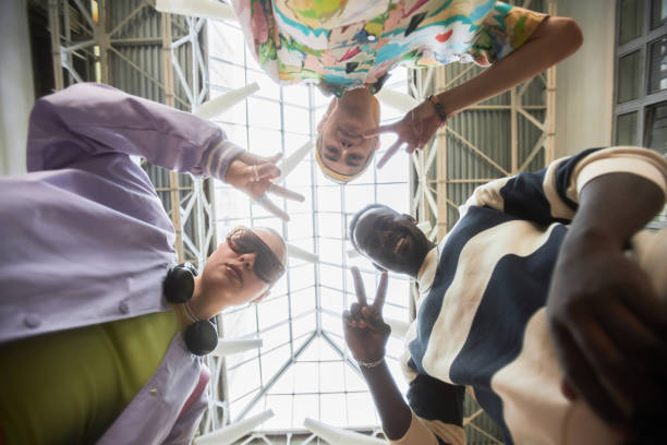 Multiethnic group of young people looking down at camera in circle