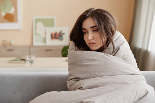 istock Sad young woman wrapped in blankets struggling with depression 1704668940