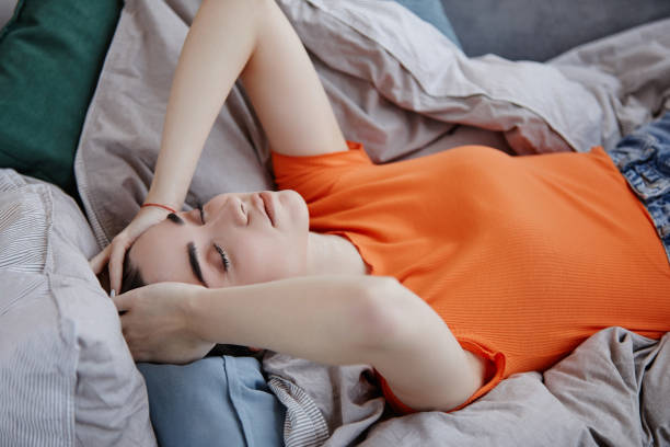 istock High angle sad young woman lying on bed in morning struggling with depression 1704668968