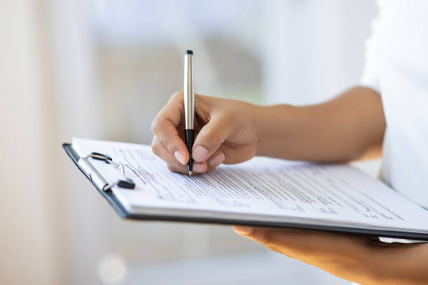 Holding clipboard and a pen in office Holding clipboard and a pen in office questionnaire stock pictures, royalty-free photos & images