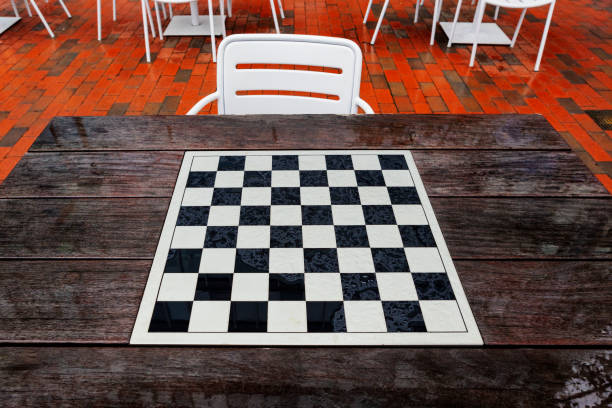 Wood table with a black and white chess and checkers board, after the rain