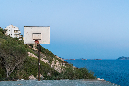 orphaned basketball court on the beach at sunset