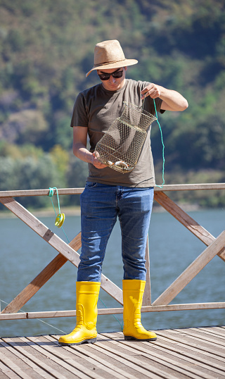 Fisherman freshwater fishing with her fishing rod in the river.