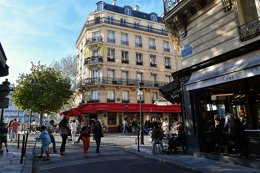 Paris, France-09 24 2023: People in a street and on the terrace of a café on the ile Saint-Louis in Paris, France.