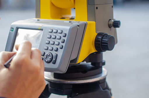 Civil engineer, surveyor is working with total station on a building site