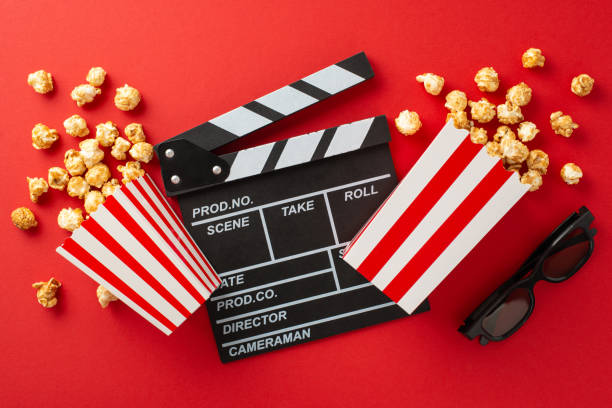 istock Friends and Flicks: Cheese and caramel popcorn, 3D glasses, and a clapperboard on red background, all ready for a fantastic movie night with your crew 1704730458