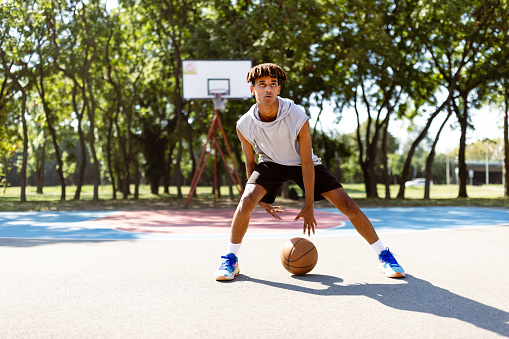 Young black basketball player working out on the outdoor court