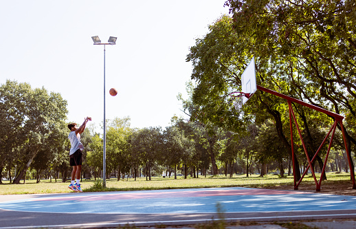 close-up of a basketball basket, rectangular white board with black lines and orange basket with net