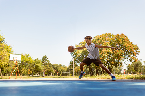 Young black basketball player working out on the outdoor court