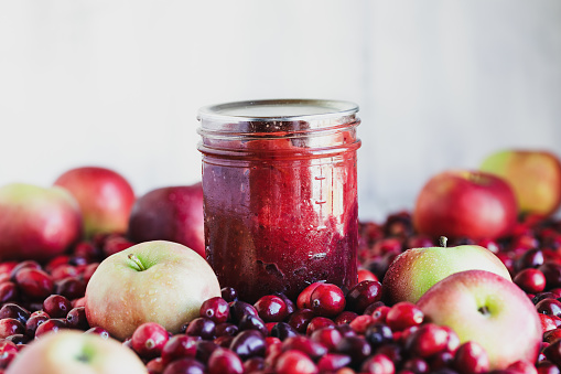 Homemade canned cranberry apple preserves with fresh fruit fruit. Selective focus with extreme blurred foreground and  background.