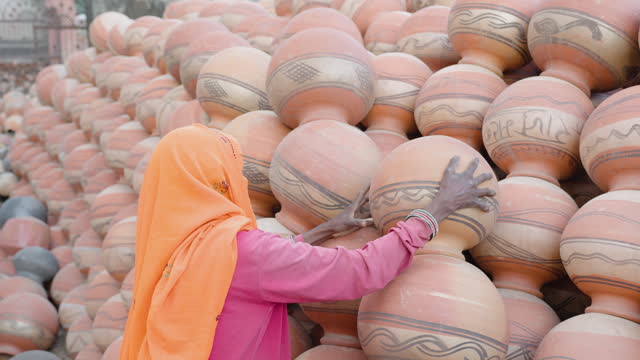 Indian woman arranging clay pots, Rajasthan, India