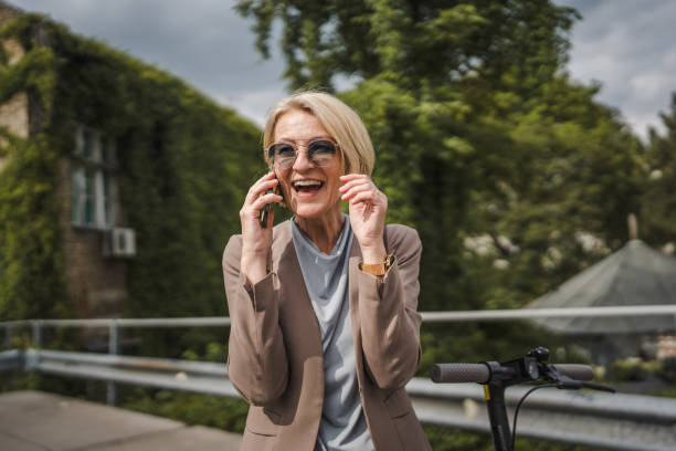 istock Woman with electric kick scooter use mobile phone smartphone make call 1704786419