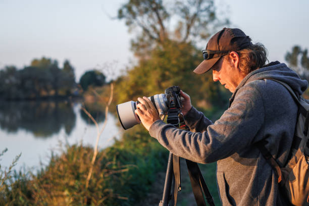istock Photographer is setting up camera on tripod outdoors 1704796616