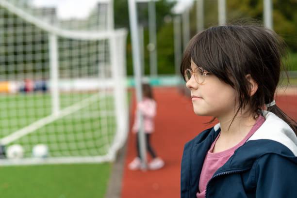 サッカー場に立つスポーツウェアと眼鏡のかわいい女の子 - soccer field grass single line lawn ストックフォトと画像