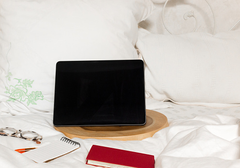 Home Office on Bed: Device, Book, Glasses, Notebook, Pillows