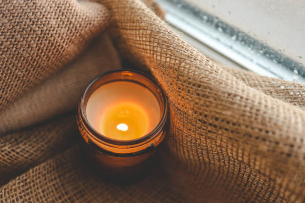 istock Burning candle close-up by the window 1704819185