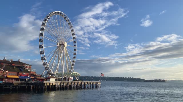 Beautiful wide shot of the famous Seattle tourist destination ferris wheel on pier 57 during golden hour on a warm sunny summer day in the state of Washington in the United States of America