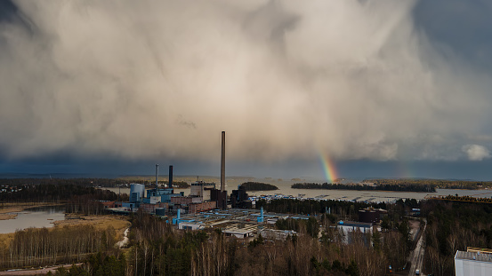 Rainbow and rain clouds in background of a huge power station.  Espoo, Finland