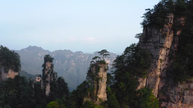Zhangjiajie Mountain range with trees on top of it at sunset. Aerial view