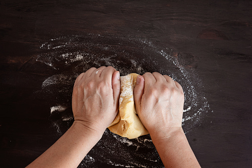 Dough in rustic style on dark wooden background. Homemade dough, bakery concept