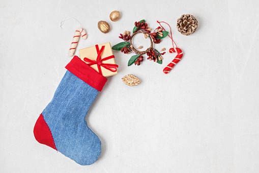 Red and blue denim Christmas stocking with gifts and decoration. Sustainble zero wastel Xmas celebration concept