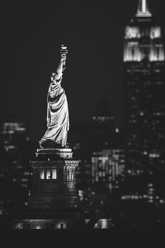 The Statue of Liberty and Empire State Building, shot from New Jersey at night. Black and White