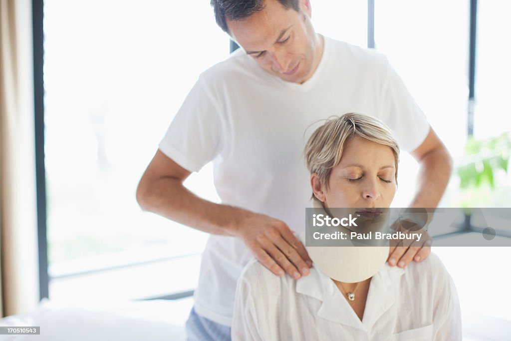 Husband helping wife in neck brace  Whiplash Stock Photo