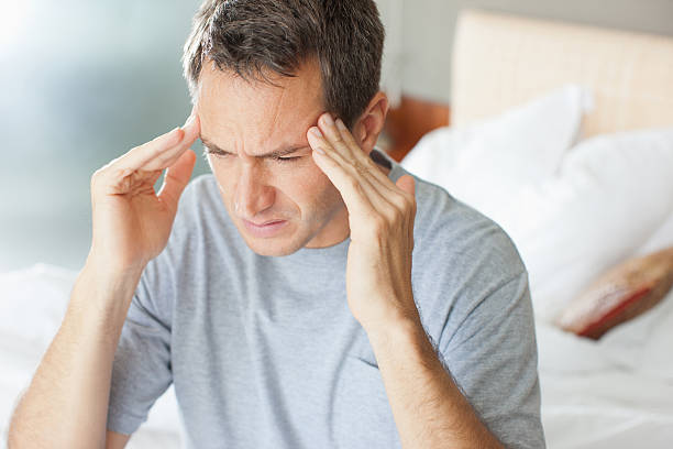 Man with headache rubbing forehead  headache stock pictures, royalty-free photos & images