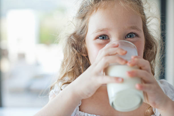 fille boire un verre de lait - calcium photos et images de collection