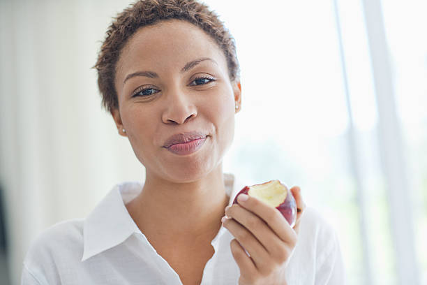 mujer comiendo manzana - apple healthy eating eating black fotografías e imágenes de stock