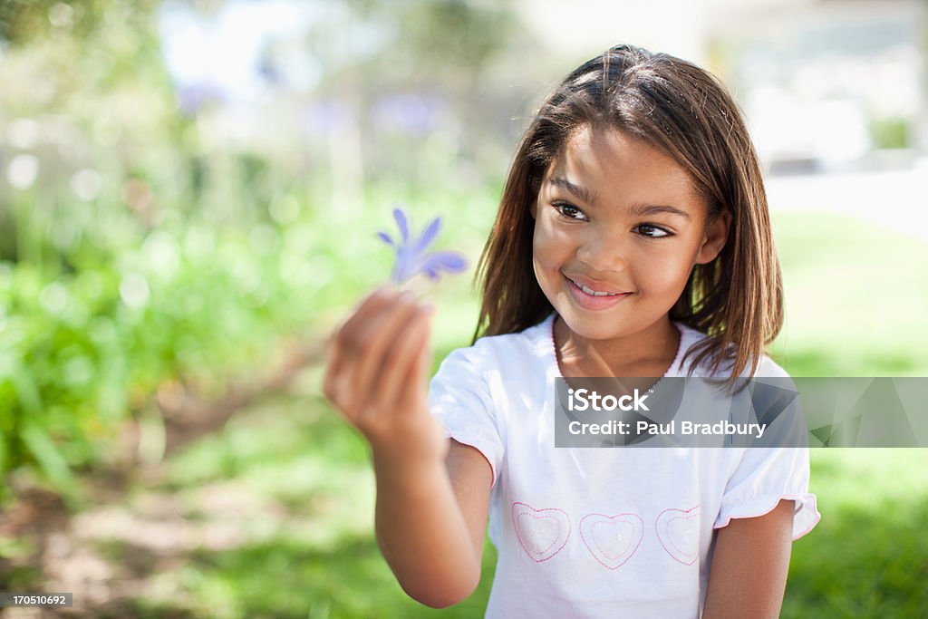 Femme tenant une fleur en plein air - Photo de 8-9 ans libre de droits