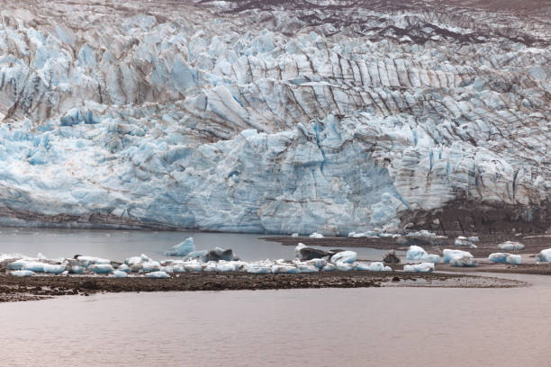 Large Glacier face and many small fragments of Ice and Earth shown as the glacier retreats