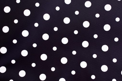 Polka dot background fabric in black and white.  Large and small dots mixed.