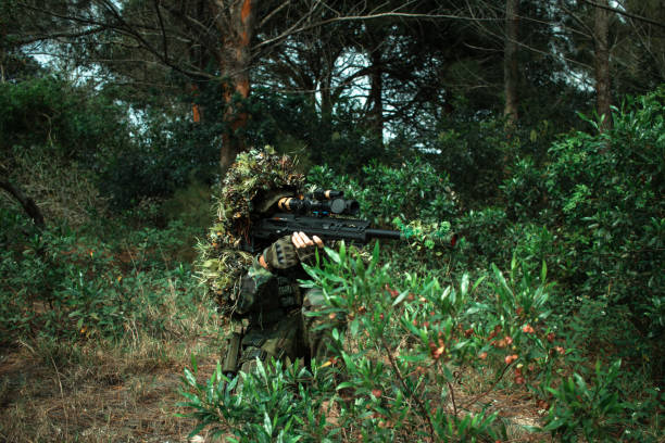 istock Ghillie suit soldier in sniper forest 1705134873