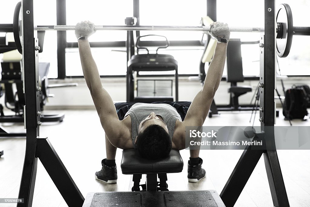 Homem levantando pesos na Mesa de supino - Foto de stock de Exercício físico royalty-free